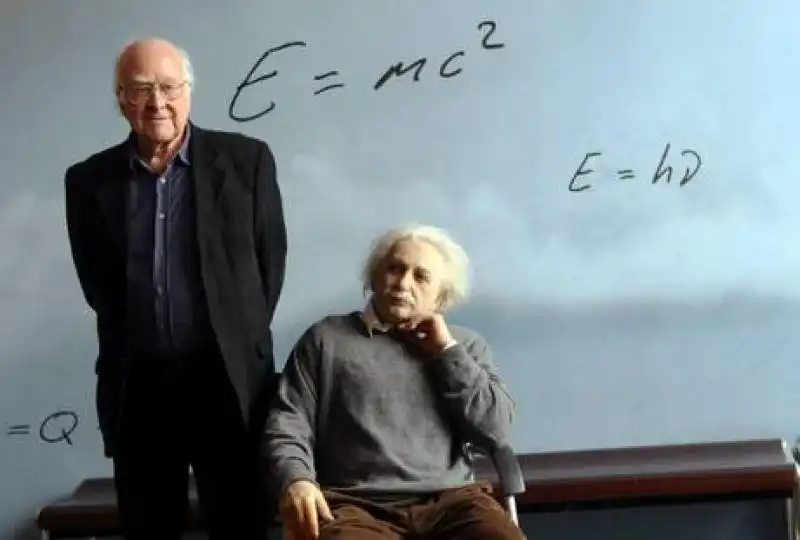 PETER HIGGS IN POSA CON UNA STATUA DI ALBERT EINSTEIN 