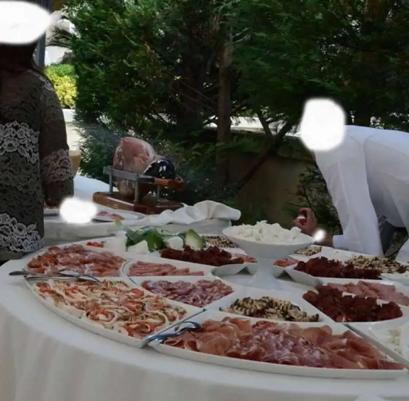 UN CAMERIERE SPRUZZA INSETTICIDA SUL BUFFET