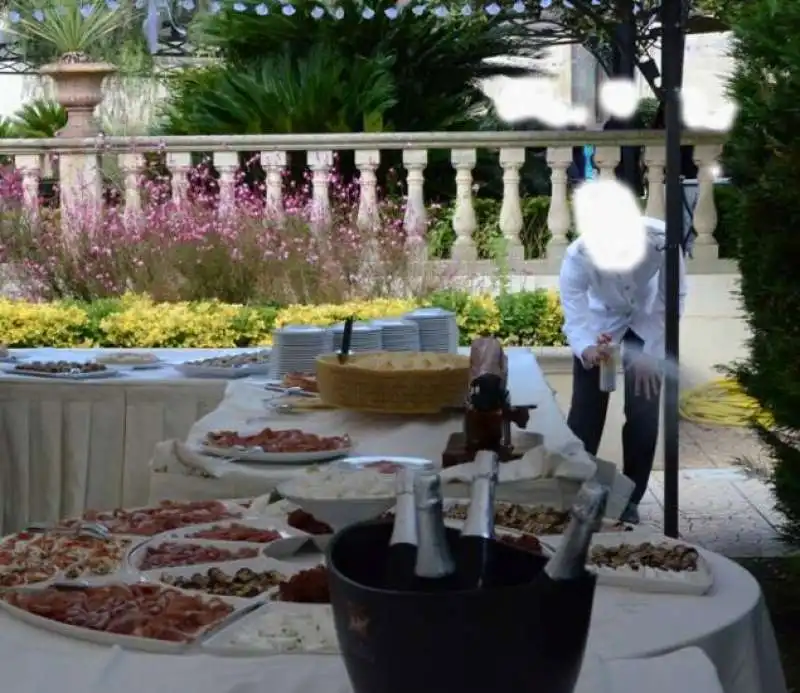 UN CAMERIERE SPRUZZA INSETTICIDA SUL BUFFET