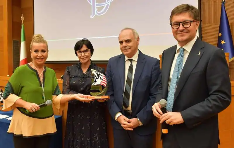 catia polidori e andrea paganella consegnano il premio america alla memoria di carlo rambaldi ai figli daniela e victor  foto di bacco