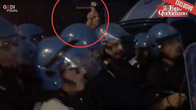 un uomo dietro la polizia riprende la manifestazione di catania nel 2018