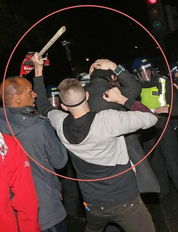 manifestante attacca la polizia con un bastone