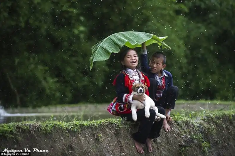 vietnam bambini si riparano dalla pioggia