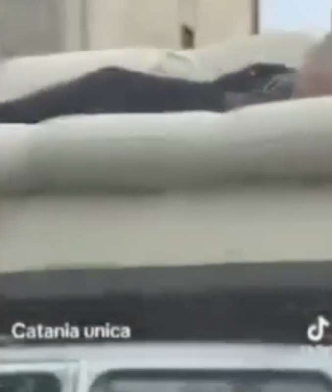 a catania un uomo e sdraiato su un divano trasportato da una macchina 1