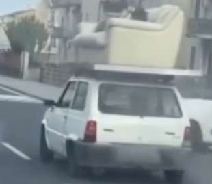 a catania un uomo e sdraiato su un divano trasportato da una macchina 3