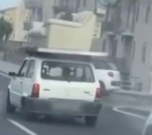 a catania un uomo e sdraiato su un divano trasportato da una macchina 4