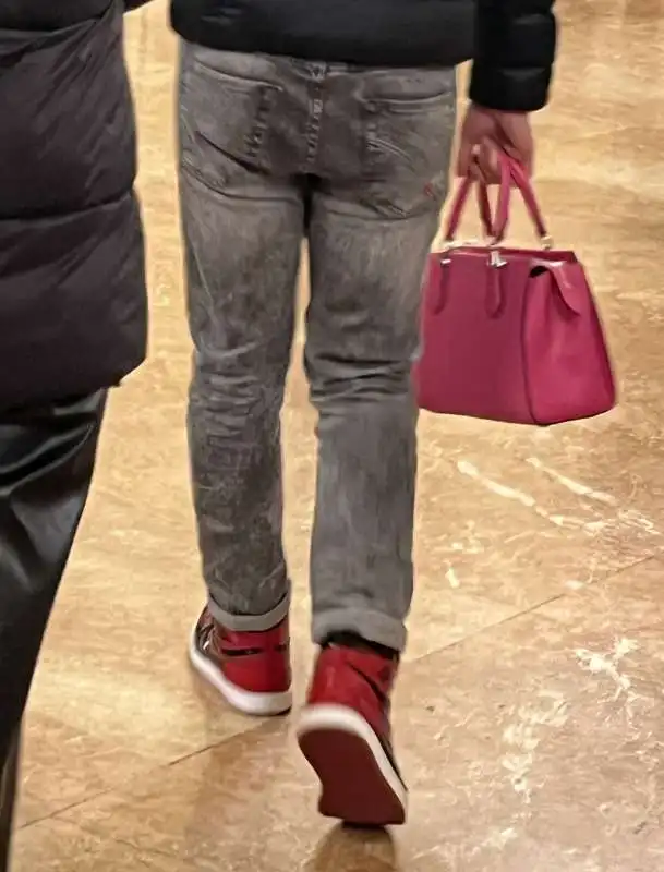 spettatore alla scala in jeans e scarpe da ginnastica