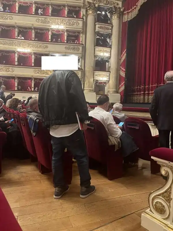 spettatore in jeans e scarpe da ginnastica alla scala 55