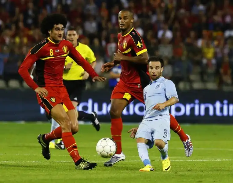 in an optical illusion frances mathieu valbuena makes a pass in front of marouane fellaini of belgium 