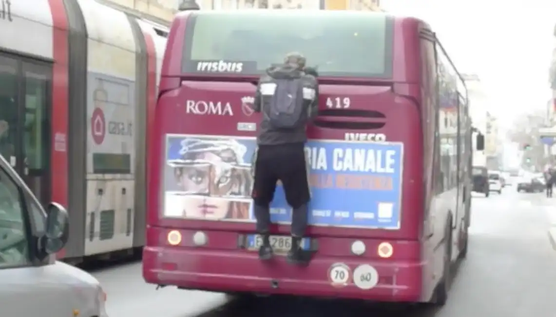 uomo aggrappato al bus roma