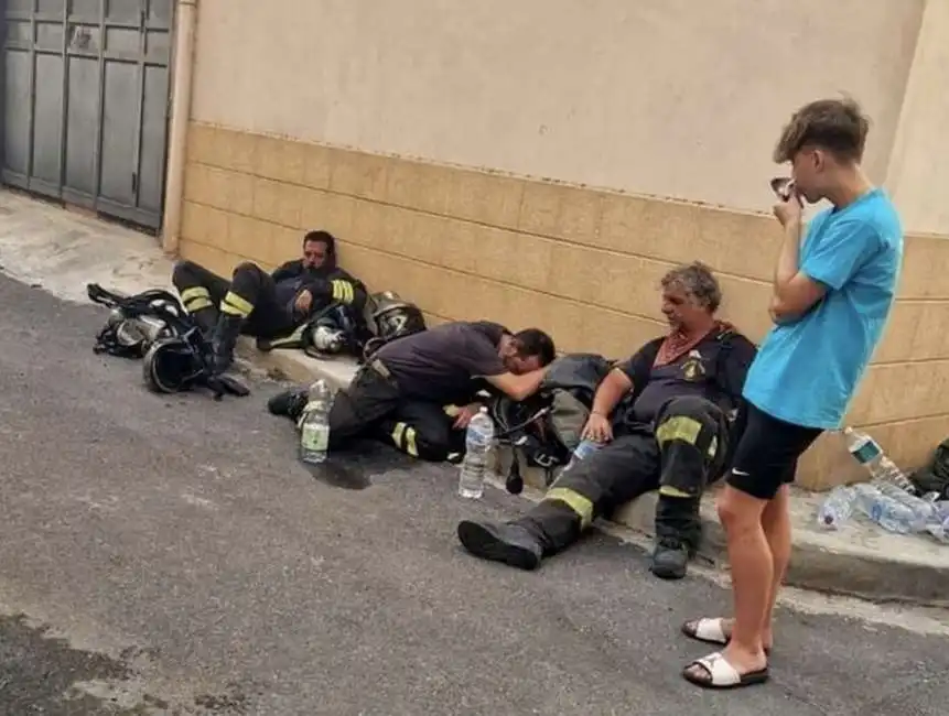 vigili del fuoco esausti sul marciapiede a siracusa pompieri 